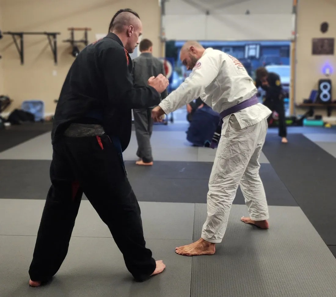 Two athletes grappling for a hold on the mats at Glacier Grappling & MMA