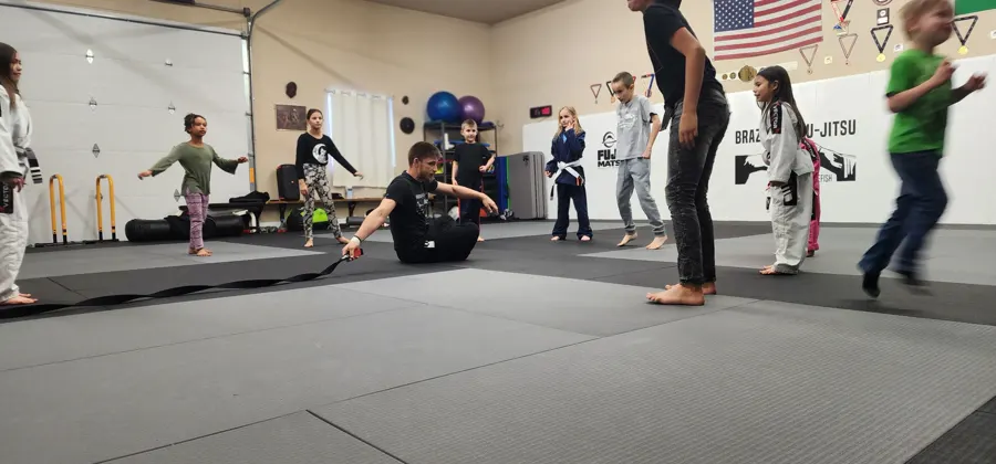 Young students running drills with a coach on the mats at Glacier Grappling & MMA