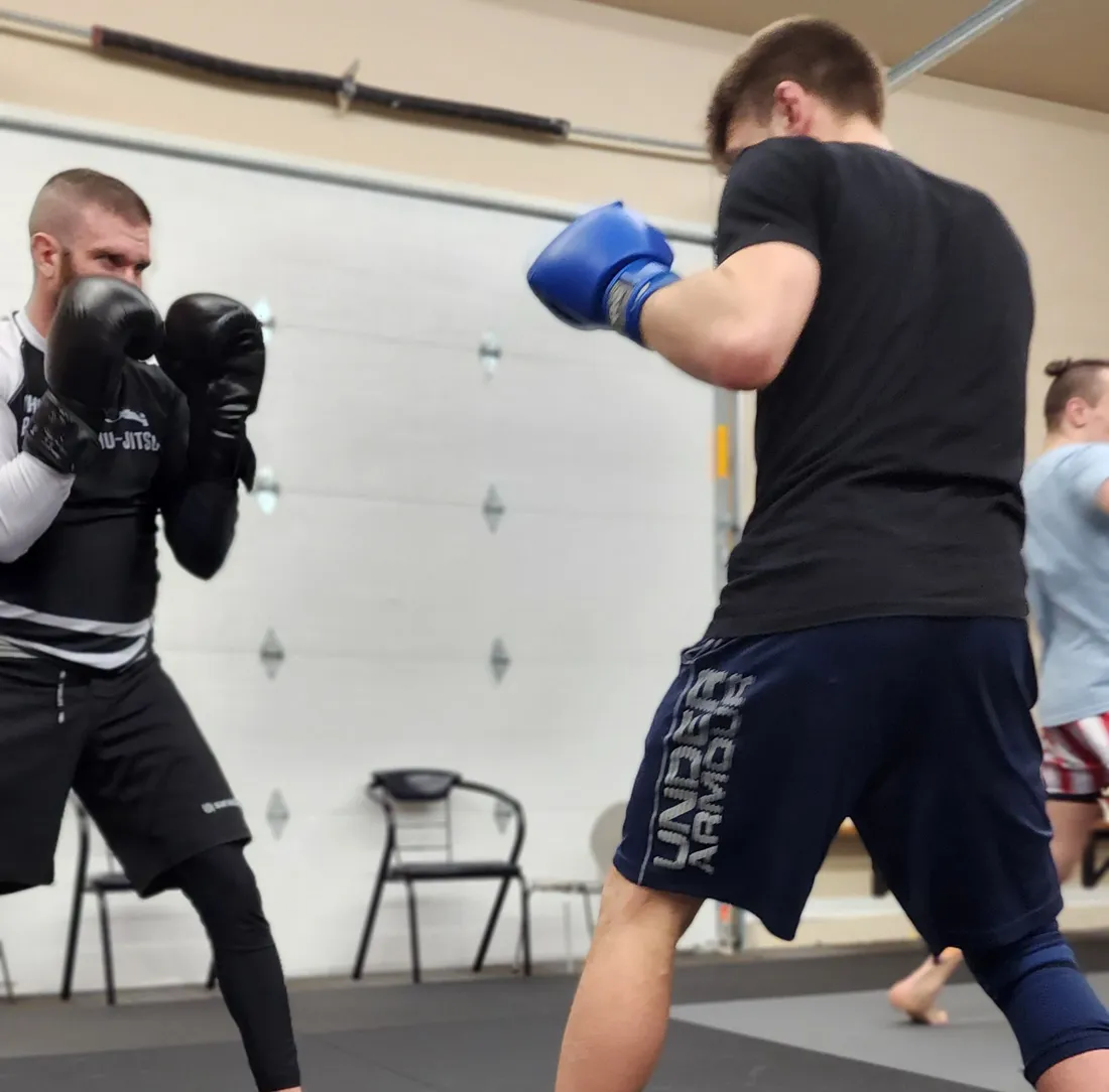 Two students sparring in boxing gloves during a kickboxing class at Glacier Grappling & MMA